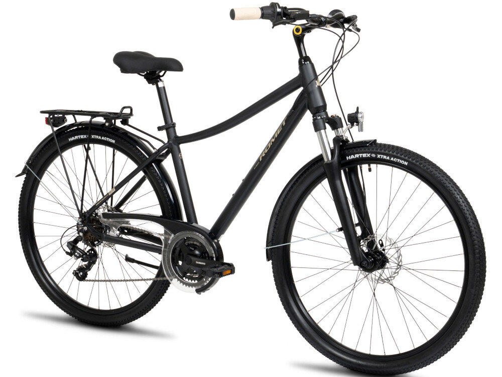 Czarny rower trekkingowy z amortyzowanym widelcem, bagażnikiem i oponami marki HARTEX XTRA ACTION. Na ramie widoczny jest napis \'ROMET\'.