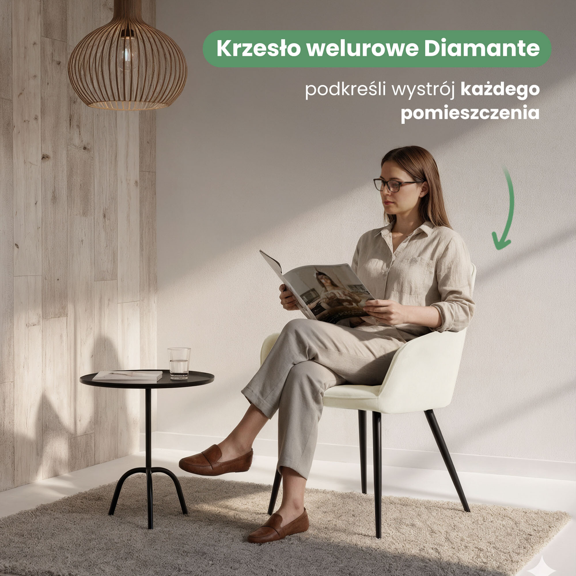 Osoba siedzi na kremowym, welurowym krześle z czarnymi nogami, obok znajduje się mały stolik z szklanką i czasopismem. Na obrazie widoczny jest tekst: \'Krzesło welurowe Diamante podkreśli wystrój każdego pomieszczenia\'.