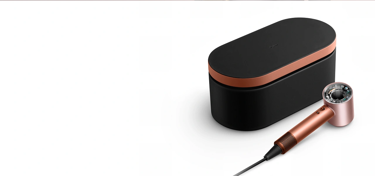 Etui prezentowe i suszarka Dyson Supersonic Nural leżą na blacie.