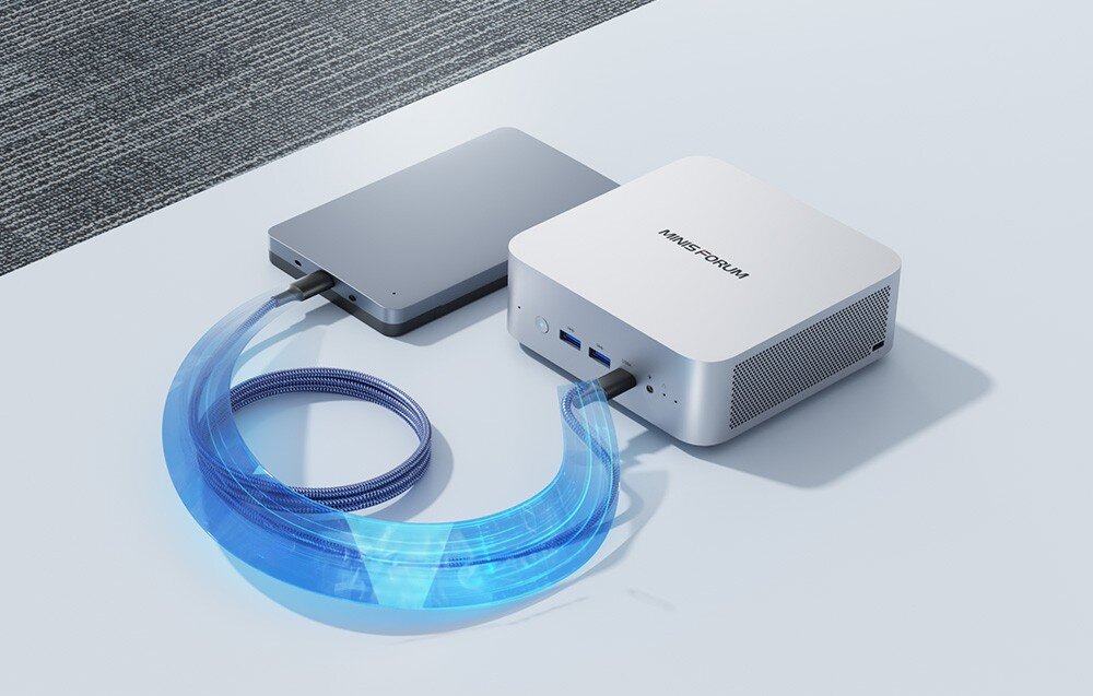 Komputer MINISFORUM X1-255 Kompaktowy komputer podłączony kablem do zewnętrznego dysku na jasnej powierzchni