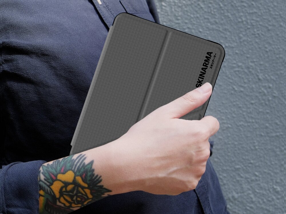 Etui na Kindle 11 SKINARMA Trax Gunmetal, etui, skinarma, kindle, design, etui trzymane jest w dłoni pod pachą osoby