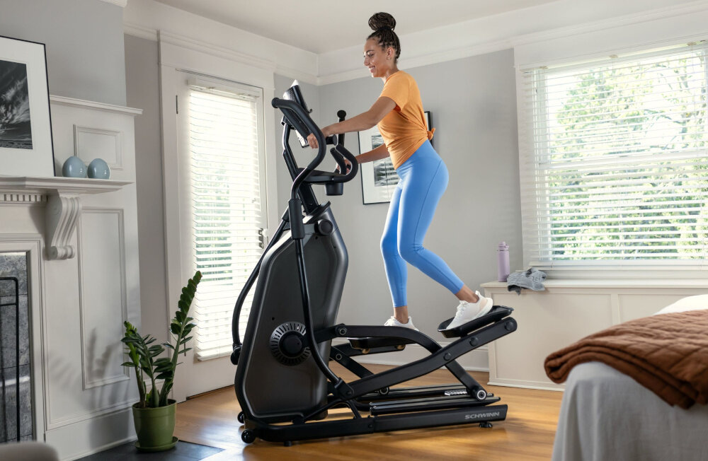 Orbitrek eliptyczny SCHWINN 590E 18kg 51cm osoba ćwiczy na orbitreku w pomieszczeniu kondycja poprawa wydolnośći dbanie o zdrowie trening w domu