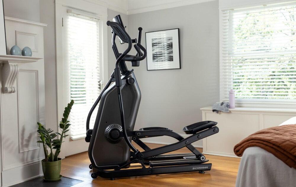 Orbitrek eliptyczny SCHWINN 590E 18kg 51cm urządzenia stoi w pomieszczeniu poprawa kondycji spalanie kalorii wzmacnianie mięśni bez obciążania stawów płynny ruch eliptyczny angażuje całe ciało trening w komfortowych warunkach domowych