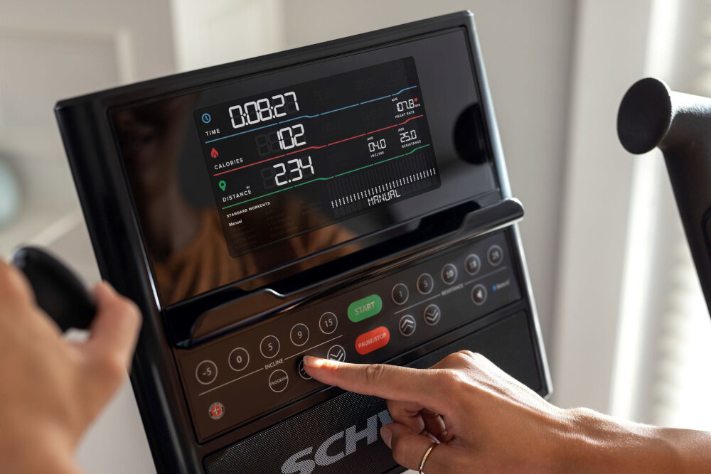 Orbitrek eliptyczny SCHWINN 590E 18kg 51cm osoba dotyka palcem wyświetlacza 7-calowy wyświetlacz LCD śledzenie kluczowych parametrów pełna kontrola nad swoimi postępami pomiar tętna za pomocą pasa telemetrycznego brak w zestawie