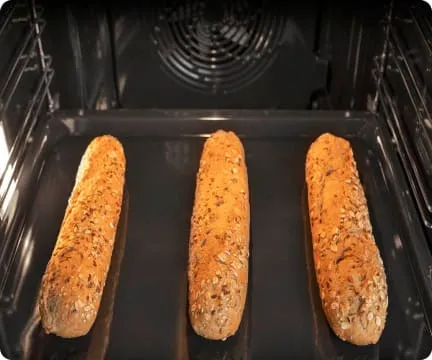 Trzy podłużne bułki znajdujące się wewnątrz piekarnika Hisense
