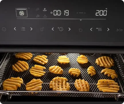 Wnętrze piekarnika z piekącymi się okrągłymi frytkami w kratkę