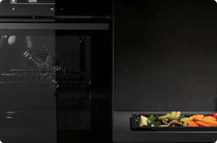 Piekarnik Hisense a obok blat kuchenny z blaszaną tacą pełną warzyw