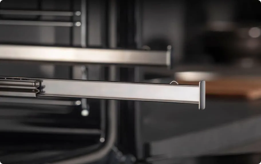 Zbliżenie na metalowe prowadnice teleskopowe w piekarniku Hisense