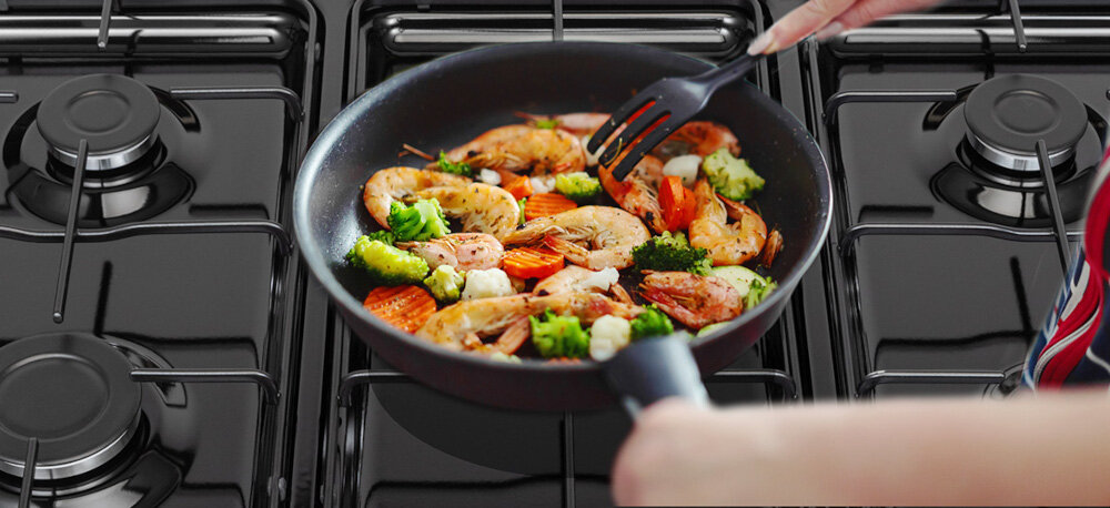 KUCHNIA DAEWOO F96CGDTE19INM-PL wizualizacja lifestyle patelnia danie warzywa smażenie krewetki widelec Gazowa płyta z palnikiem wok 5 stref gotowania szybkie gotowanie wysoka moc kontrola precyzja