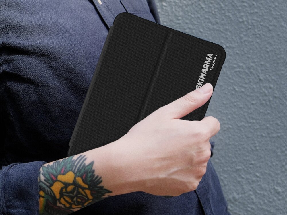 Etui na Kindle Paperwhite 12 SKINARMA Trax Czarny, etui, skinarma, kindle, elegancja, etui trzymane jest w dłoni pod pachą osoby