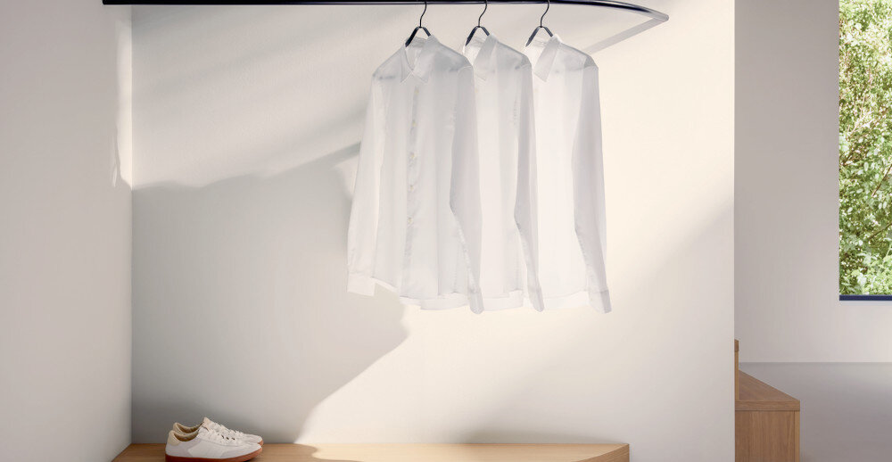 SUSZARKA MIELE TQ 1000 WP NOVA EDITION zdjęcie lifestyle białe koszule wieszaki ubrania buty ściana System pary SteamCare funkcja parowa odświeżanie wygładzanie Pre-ironing Extra neutralizuje zapachy flakon perfumy do tkanin