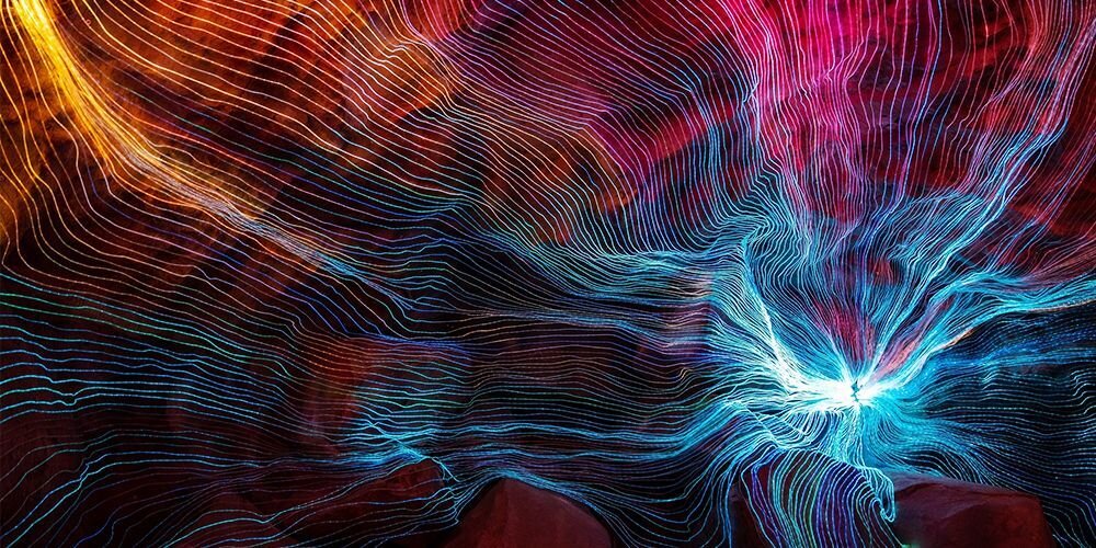 Abstrakcyjna grafika z liniami świetlnymi w odcieniach niebieskiego, różowego i pomarańczowego, dynamiczny efekt świetlny.  