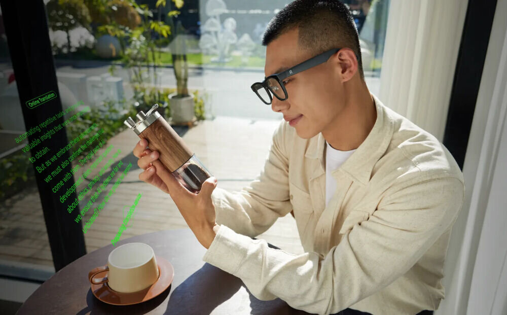 Asystent AI inteligentne napisy transkrypcji Mężczyzna siedzący przy kawiarnianym stoliku analizuje przedmiot przez okulary AR Rokid, które nakładają na widok tekstowy opis dotyczący automatyzacji i sztucznej inteligencji