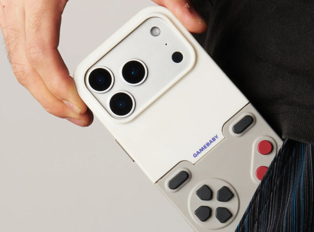 GameBaby fizyczne przyciski kontrolera Smartfon w etui GameBaby z widocznym aparatem, wysuwany z kieszeni spodni – szary wariant kolorystyczny.