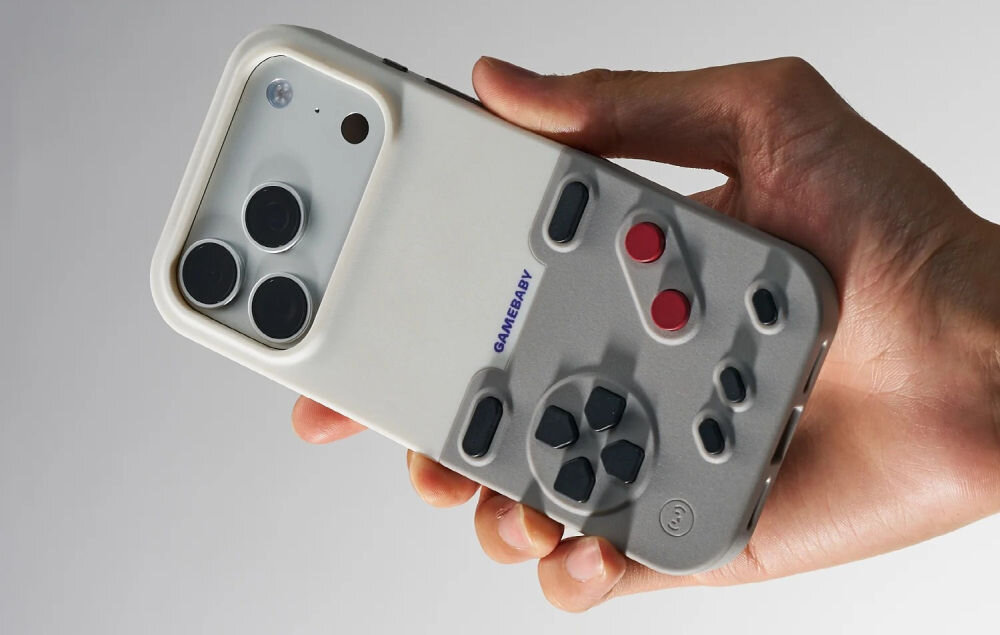 GameBaby etui z kontrolerem iPhone Dłoń trzymająca iPhone'a w etui GameBaby od Bitmo Lab w kolorystyce klasycznego Game Boya. Widoczny tył telefonu z odsłoniętym potrójnym aparatem oraz szary dolny moduł z czerwonymi przyciskami i czarnym krzyżakiem sterującym.