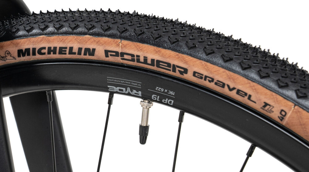 Zbliżenie na oponę rowerową z widocznym bieżnikiem i napisem \'MICHELIN POWER Gravel\'.