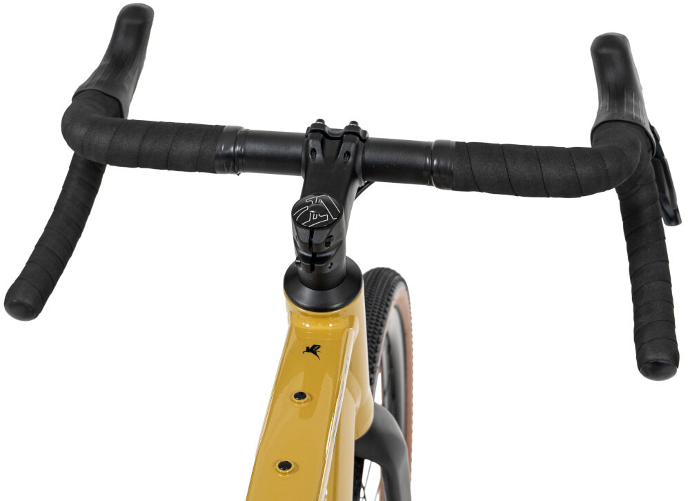 Rower gravel ROMET Aspre 2.1 2854M110-A U21 28 cali Ciemnożółty kierownica na białym tle widoczna od przodu białe tło aluminiowa kierownica RMT Components o szerokości 420 mm wspornik TranzX typu JD-ST338A 70 mm stabilne prowadzenie wspiera kontrolę nad rowerem aluminium oferuje korzystny stosunek sztywności do masy stabilne przenoszenie sił sterujących