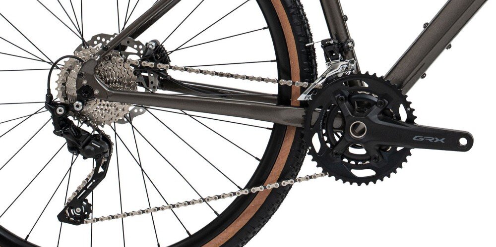 Zdjęcie przedstawia tylną część roweru z widocznym mechanizmem napędowym i łańcuchem. Na korbie znajduje się napis \'GRX\'.
