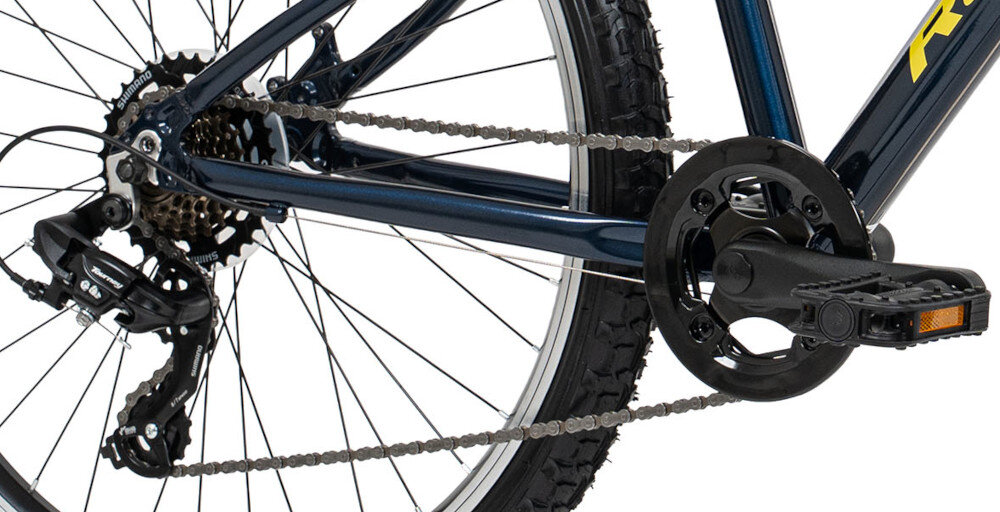 Zbliżenie na tylną część roweru z widocznym mechanizmem przerzutki, łańcuchem i pedałem. Rama roweru jest w kolorze niebieskim z żółtym napisem.