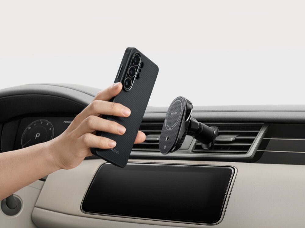 Etui PITAKA MagSafe Samsung Galaxy S26 - wytrzymałe włókno, nowoczesny splot Ręka przykładająca smartfon w etui Pitaka do magnetycznego uchwytu samochodowego zamontowanego na kratce nawiewu.