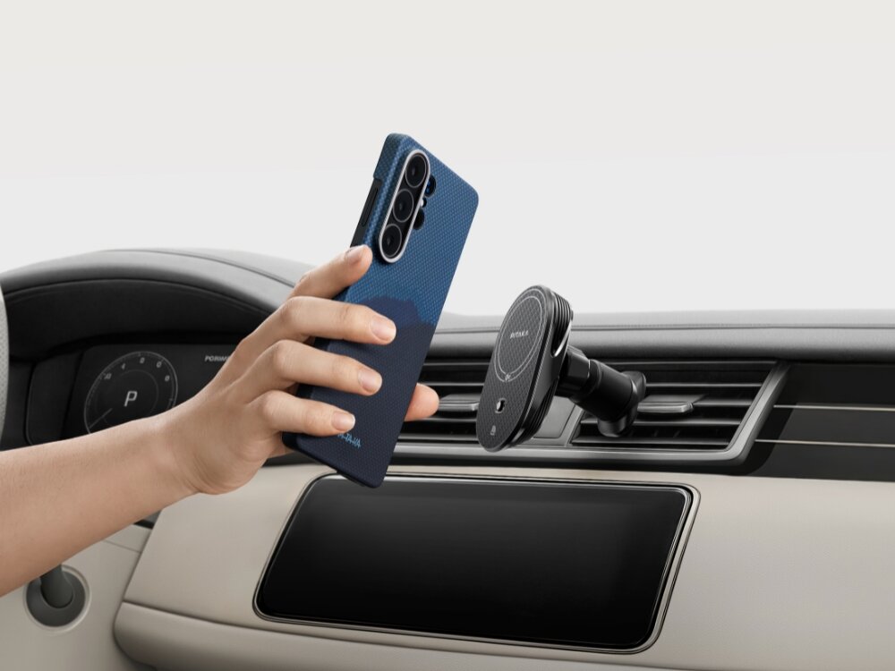 Etui PITAKA MagSafe Samsung Galaxy S26 - wytrzymałe włókno, nowoczesny splot Ręka przykładająca smartfon w etui Pitaka do magnetycznego uchwytu samochodowego zamontowanego na kratce nawiewu.