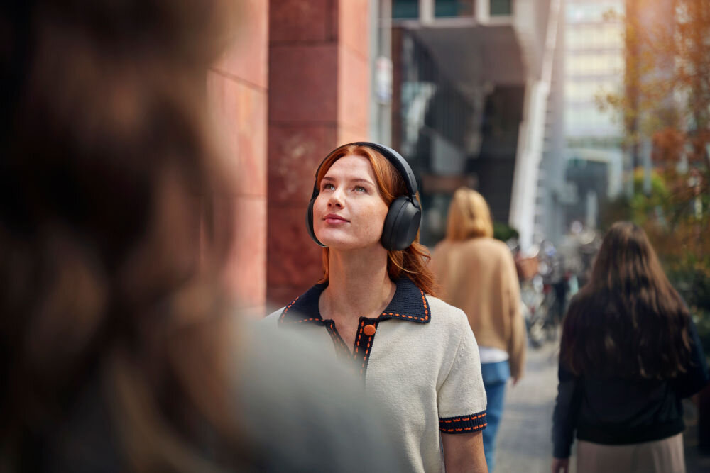 PHILIPS TAH8000EBK/00 słuchawki ciepły dźwięk, szczegółowe tony, głęboki bas, osoba z założonymi słuchawkami nausznymi w plenerze