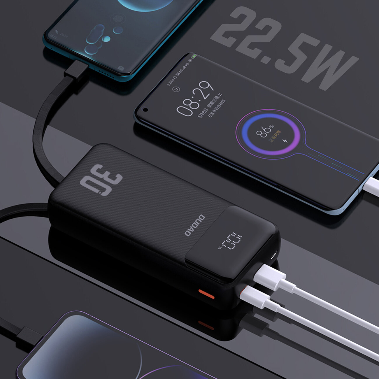 Na obrazie widoczny jest czarny powerbank z logo \'DUDAO\' i wyświetlaczem pokazującym \'100%\'. Obok znajdują się dwa smartfony podłączone do powerbanka, a na powierzchni widoczny jest napis \'22.5W\'.