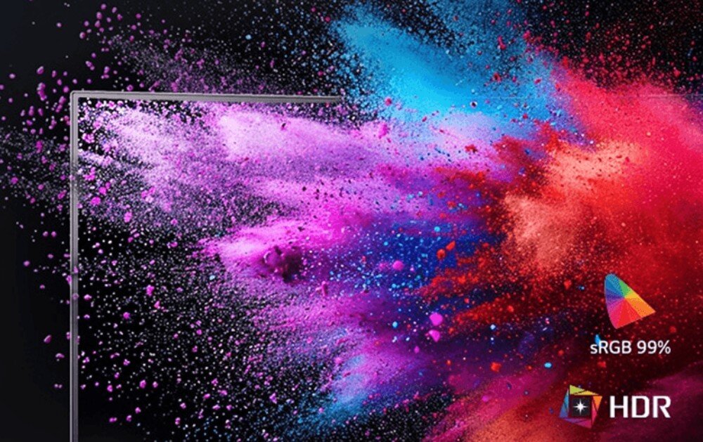 Obraz przedstawia kolorowy wybuch farb w odcieniach różu, fioletu, niebieskiego i czerwonego na czarnym tle. Widoczne są napisy \'sRGB 99%\' oraz \'HDR\' z odpowiednimi ikonami.