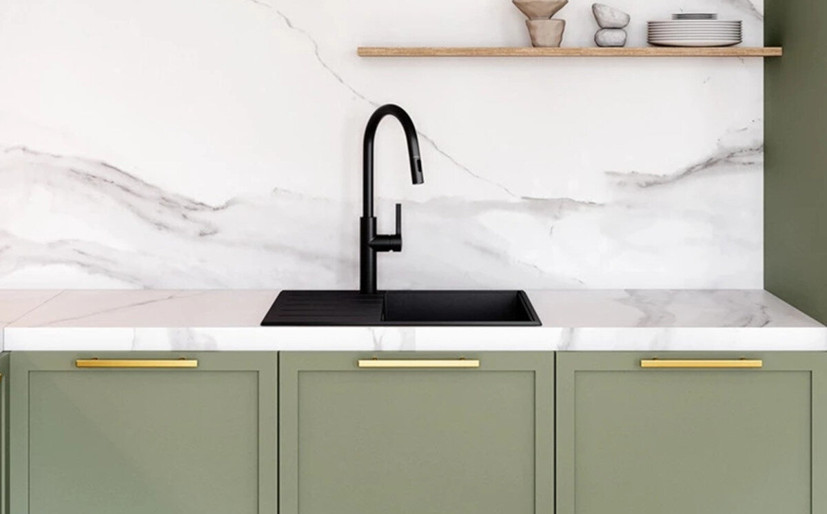 Zlewozmywak jednokomorowy z ociekaczem GLOBALO Design Virella 45.1 Zbliżenie na czarny zlew z ociekaczem oraz czarną baterię, zamontowane na jasnym marmurowym blacie w zielonej zabudowie kuchennej zlew granitowy syfon czarny design funkcjonalność kuchnia