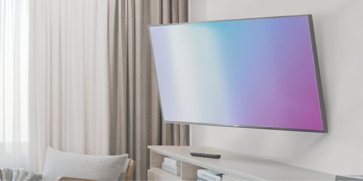 Uchwyt HAMA do TV 37-90 cali Fullmotion 220852 Nowoczesny telewizor zamontowany na ruchomym uchwycie ściennym, nachylony pod kątem w dół w salonie.