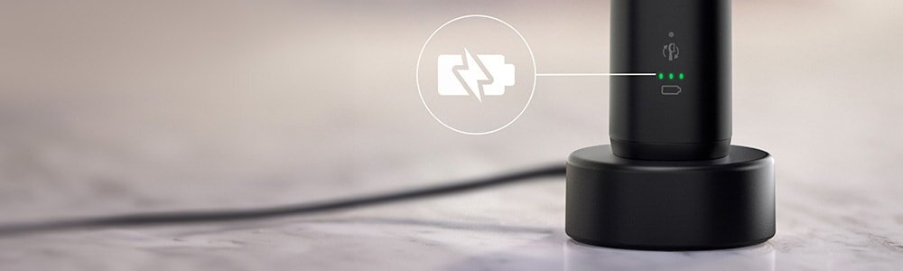 Szczoteczka podłaczona do ładowarki. Zbliżenie na ikonę baterii.