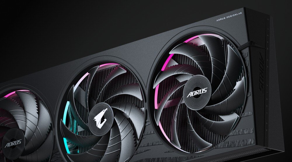 Karta graficzna GIGABYTE GeForce RTX 5060 Aorus Elite 8GB Karta graficzna zaprezentowana w perspektywie z widocznymi trzema podświetlanymi wentylatorami otoczonymi pierścieniami świetlnymi