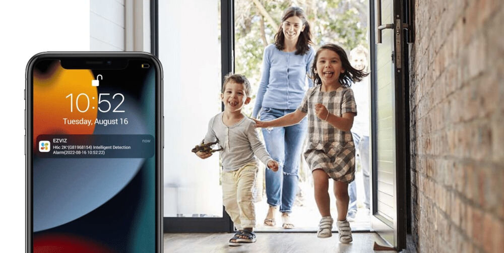 Kamera EZVIZ H6C PRO 3K - Powiadomienia o zdarzeniach, smartfon na pierwszym planie, wbiegające dzieci do domu, za nimi kobieta
