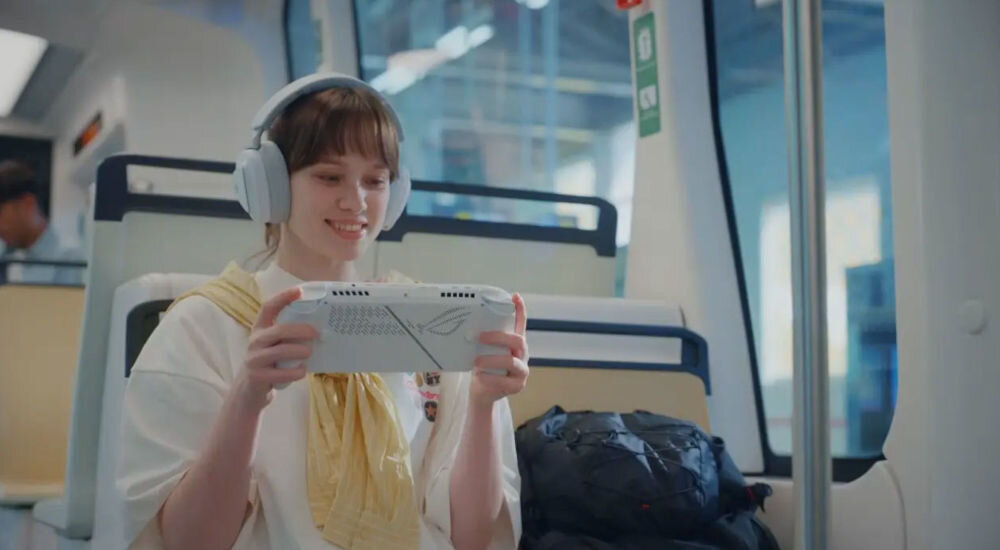 ASUS ROG Xbox Ally RC73YA biały kobieta siedząca w transporcie publicznym i grająca na konsoli akumulator 60 Wh długi czas pracy mobilność