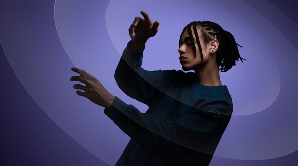 Słuchawki Redmi Buds 6 Pro funkcjonalnosc intuicyjnosc korektor graficzny - jobieta z sluchawkami w uszach unoszaca rece - jakby tanczyla
