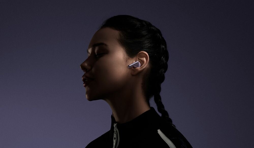 Słuchawki Redmi Buds 6 Pro sluchawki w uszach kobiety ktora stoi na ciemnym tle - przetworniki tytan ceramika wspolpraca hi-fi sledzenie ruchow glowy 