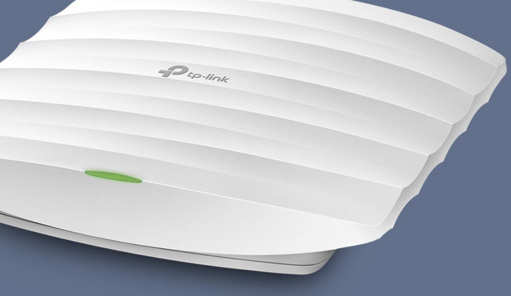 Punkt dostępowy TP-LINK EAP115 Zbliżenie na biały punkt dostępowy z logo producenta, widoczne delikatne poziome przetłoczenia i zielona dioda na obudowie, działanie, łączność Wi-Fi, pasmo 2,4 GHz, przepustowość