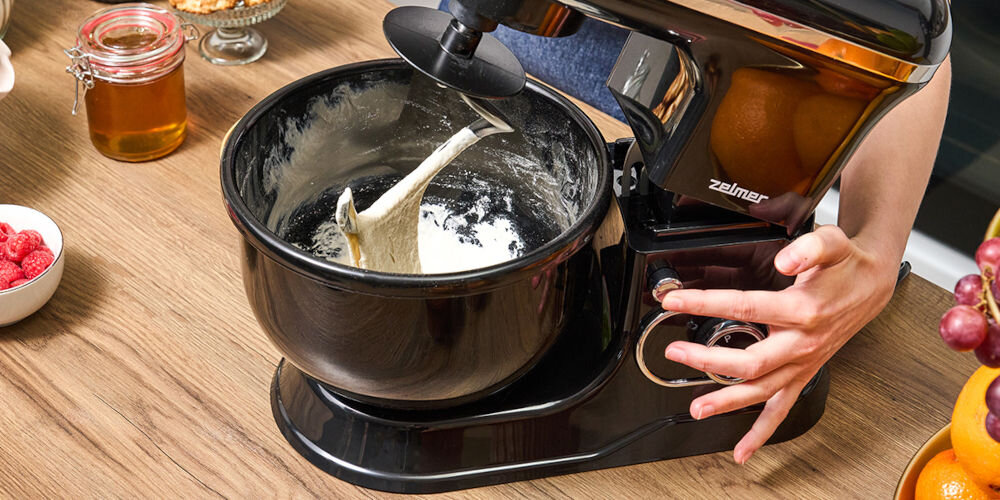 Robot planetarny ZELMER ZKR1355 1200W czarny robot na blacie zamontowana końcówka masa w misce pokrętło ręka trzymająca przycisk ergonomiczne pokrętło płynna regulacja na sześciu poziomach dostosowanie tempa pracy funkcja Pulse dynamiczne zwiększanie i zmniejszanie obrotów optymalne połączenie uzyskanie pożądanej konsystencji