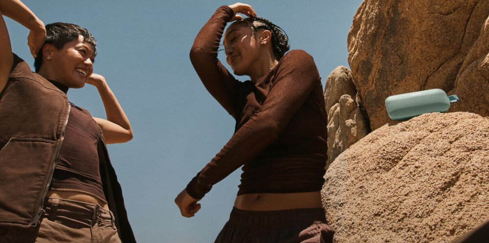 Głośnik mobilny BOSE SoundLink Flex 2 gen połączenie stereo tryb party dwa głośniki BOSE, osoby tańczące w rytm muzyki, głośnik stojący na skale