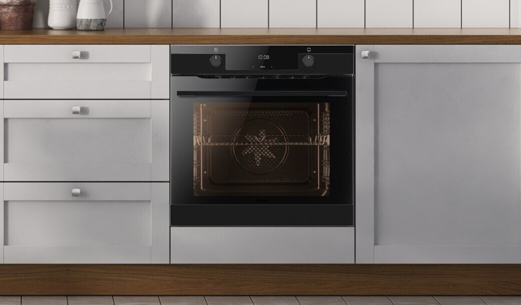 Piekarnik Amica w pozycji włączonej w jasnej zabudowie kuchennej z uchwytami