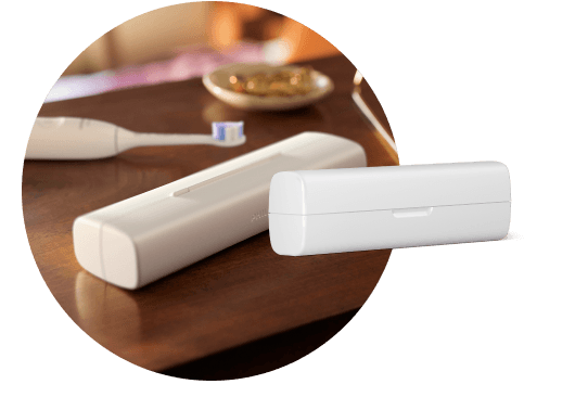 Na blacie leży etui, a za nim szczoteczka. Obok znajduje się etui podróżne.