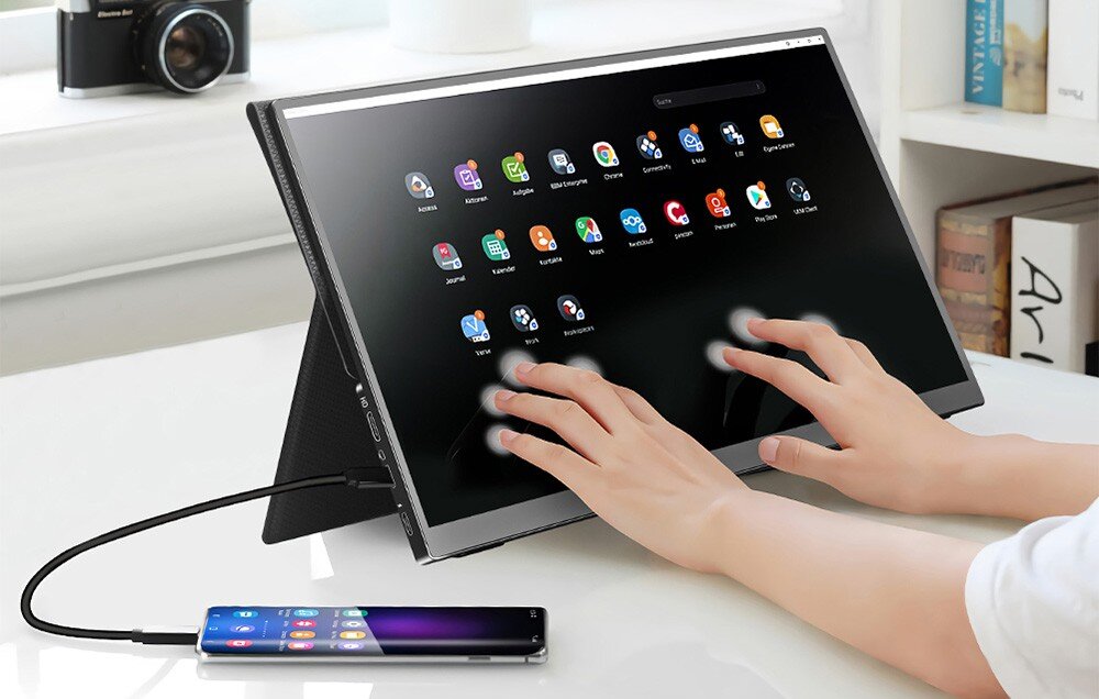 Monitor ARZOPA A1T Osoba korzysta z dużego ekranu dotykowego, podłączonego do smartfona za pomocą przewodu USB-C; na ekranie wyświetlony interfejs z ikonami aplikacji, opis