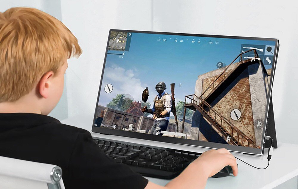 Monitor ARZOPA A1T Dziecko siedzi przy biurku i gra na przenośnym monitorze podłączonym do klawiatury; na ekranie widoczna gra typu strzelanka w trybie pierwszoosobowym, porty, kompatybilność, podłączenie