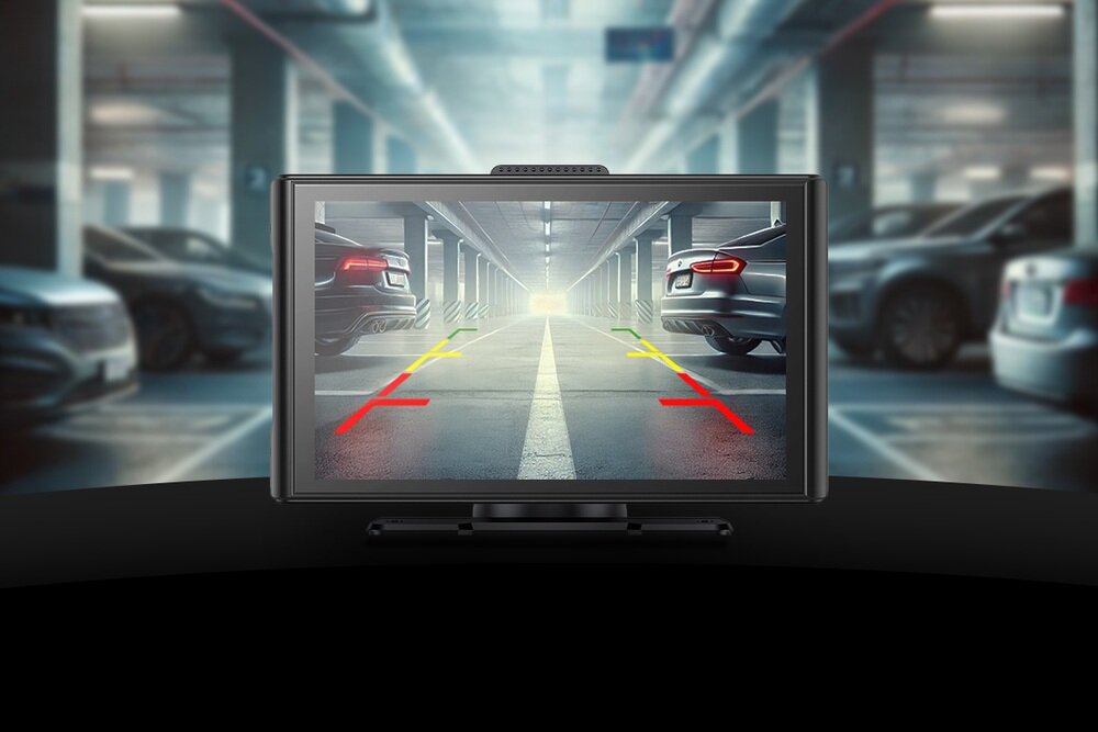 Na ekranie tabletu multimedialnego wyświetlany jest obraz z kamery cofania, przedstawiający wnętrze parkingu z liniami pomocniczymi w kolorach czerwonym, żółtym i zielonym. W tle widoczne są zaparkowane samochody.