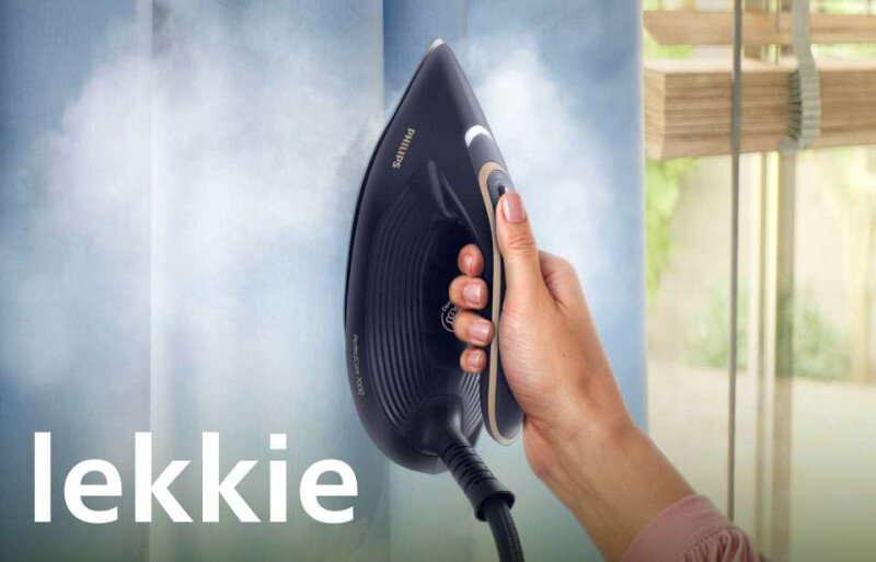 Osoba trzyma generator pary, który emituje parę na niebieską tkaninę. Na obrazie widoczny jest tekst \'lekkie\' oraz logo \'PHILIPS\'.