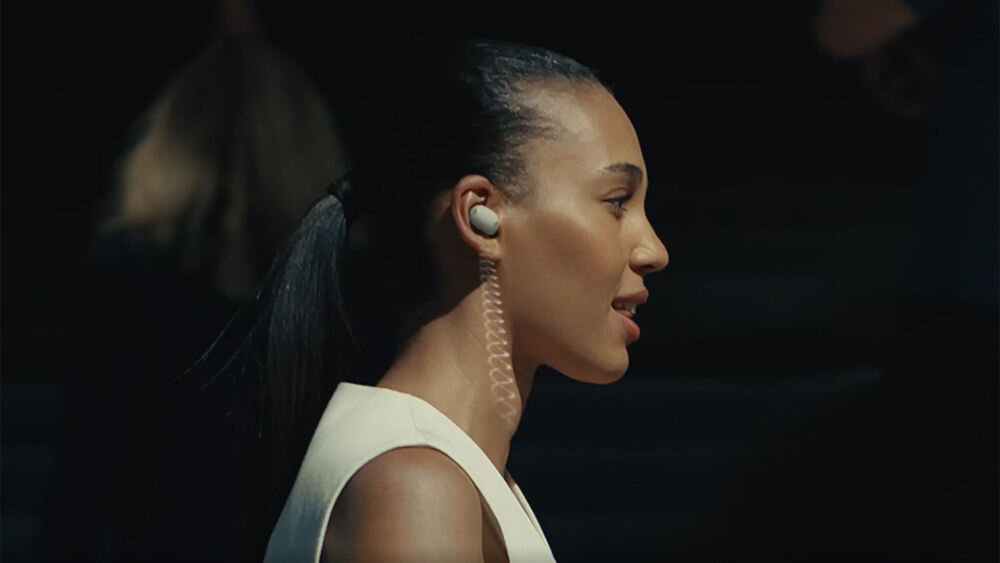 Słuchawki dokanałowe SONY WF-1000XM6 ANC Profil kobiety z bliska prezentujący dopasowanie srebrnej słuchawki Sony WF-1000XM6 do ucha.