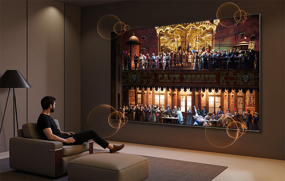 Telewizor DREAME 55S100 Google TV sterowanie głosowe tryb dziecięcy, osoba siedząca na fotelu oglądająca program w telewizji