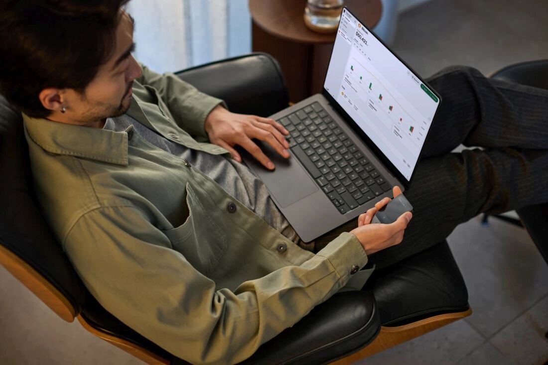 Osoba korzysta z portfela kryptowalut Trezor Safe podłączonego do laptopa podczas zarządzania środkami w domu - Cyfrowy portfel  