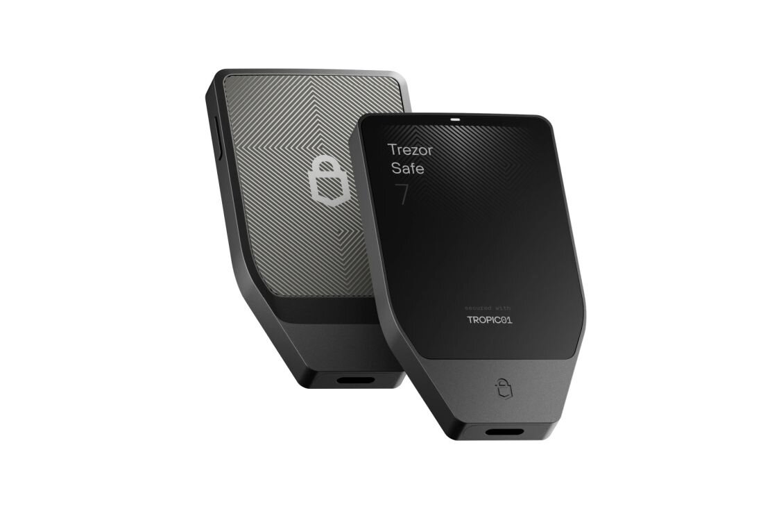 Dwa portfele kryptowalut Trezor Safe pokazane pod kątem, prezentujące przód z ekranem i tył obudowy. - Chip TROPIC01  