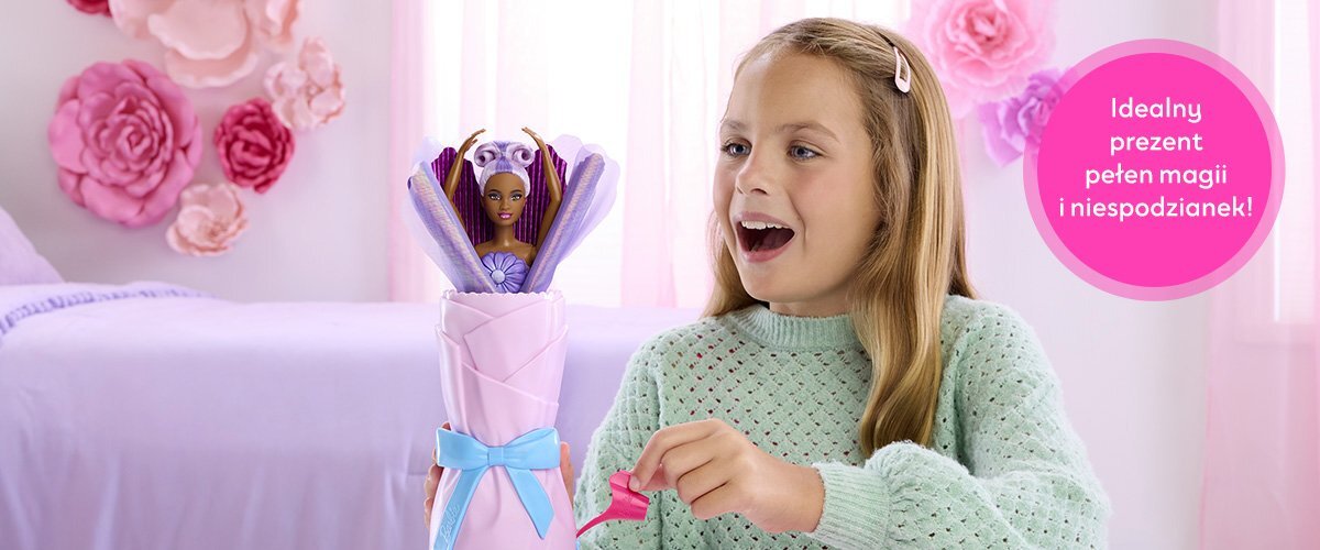 Dziewczynka bawiąca się lalką Barbie w pokoju, obok widnieje napis 'Idealny prezent pełen magii i niespodzianek!'.